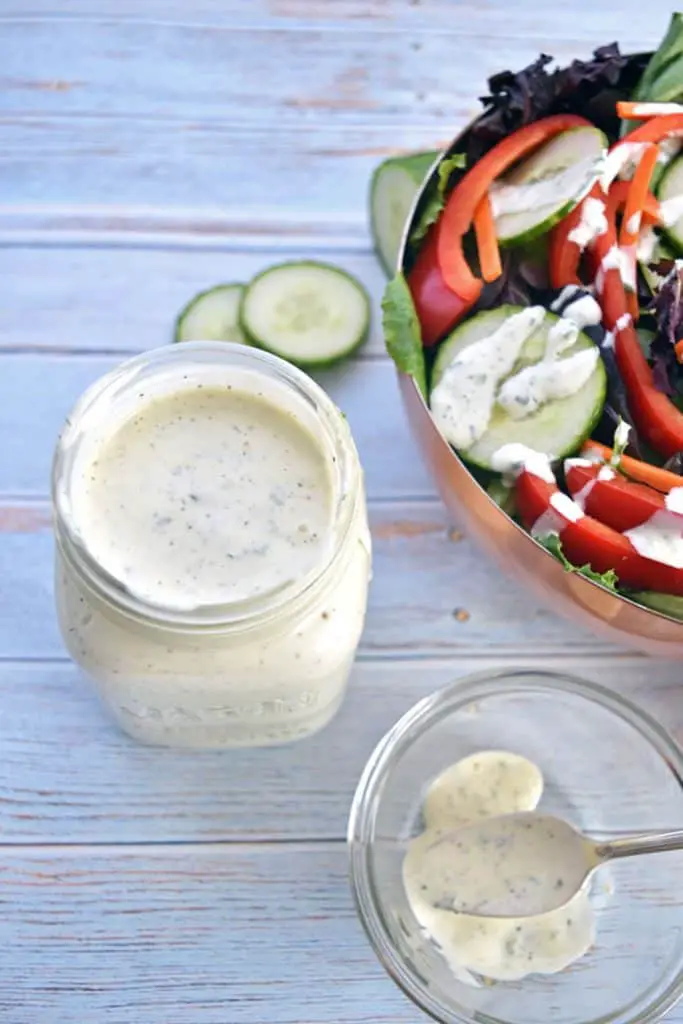 a jar of homemade low fodmap ranch dressing next to a salad