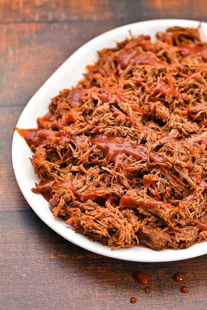 platter of low FODMAP BBQ pulled pork covered in homemade BBQ sauce