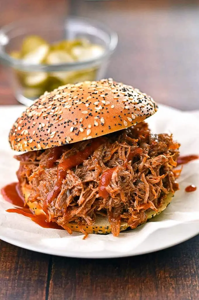 low FODMAP pulled pork covered in BBQ sauce on a gluten-free bun