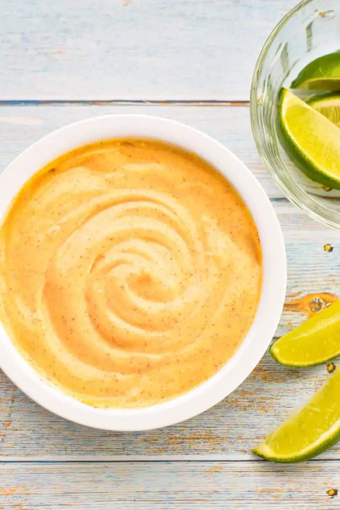 low fodmap chipotle mayo in a white bowl next to a bowl of lime wedges