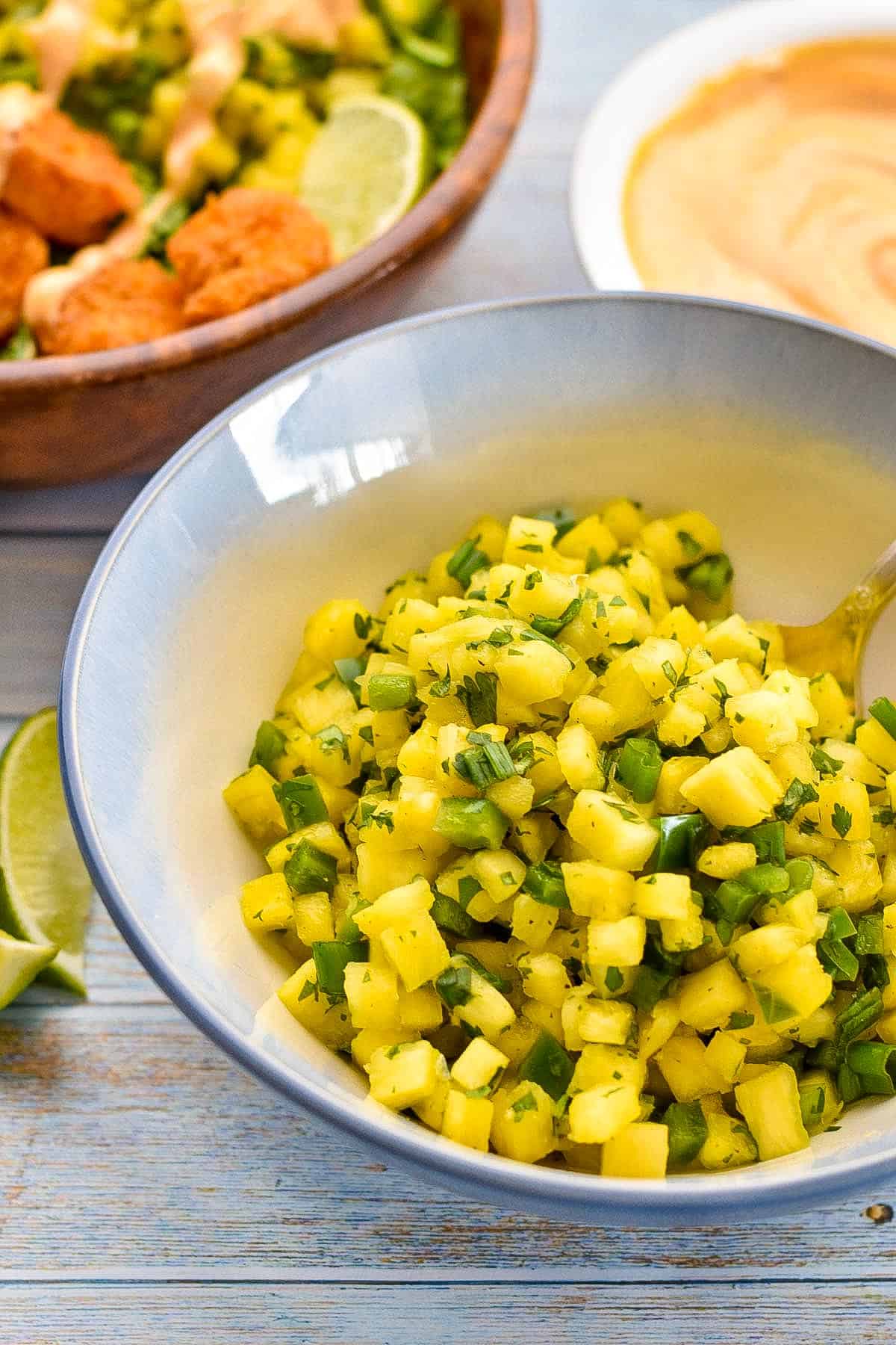 low fodmap pineapple salsa fresca in a blue and white bowl with a spoon