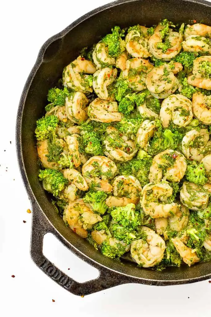 a close up of a low fodmap chimichurri shrimp and broccoli skillet on a white background