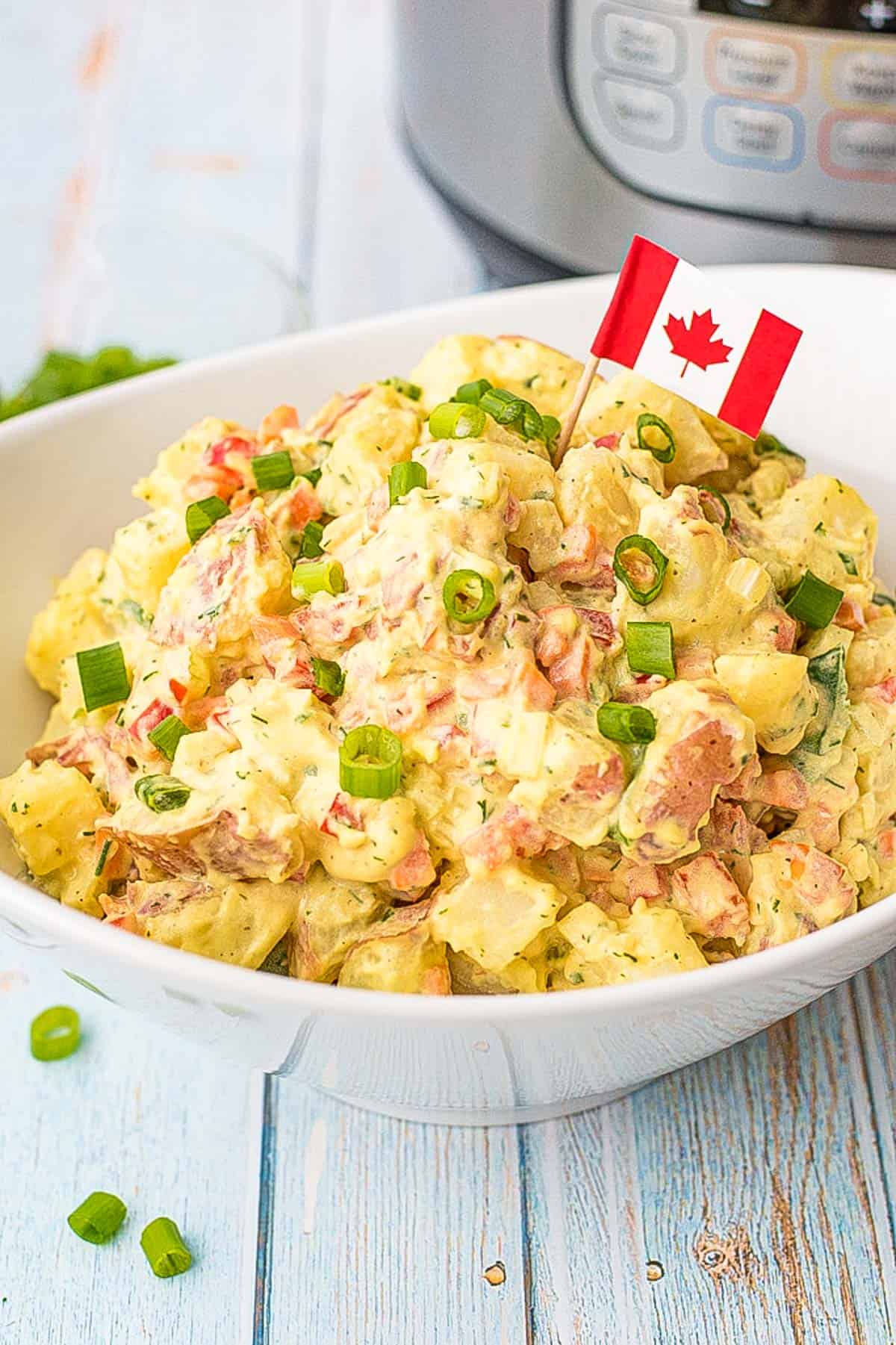 low fodmap potato salad in a white bowl with a Canadian flag toothpick in front of an  instant pot