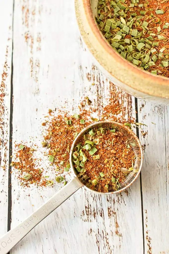 low fodmap taco seasoning in a tablespoon with seasoning spilled around it