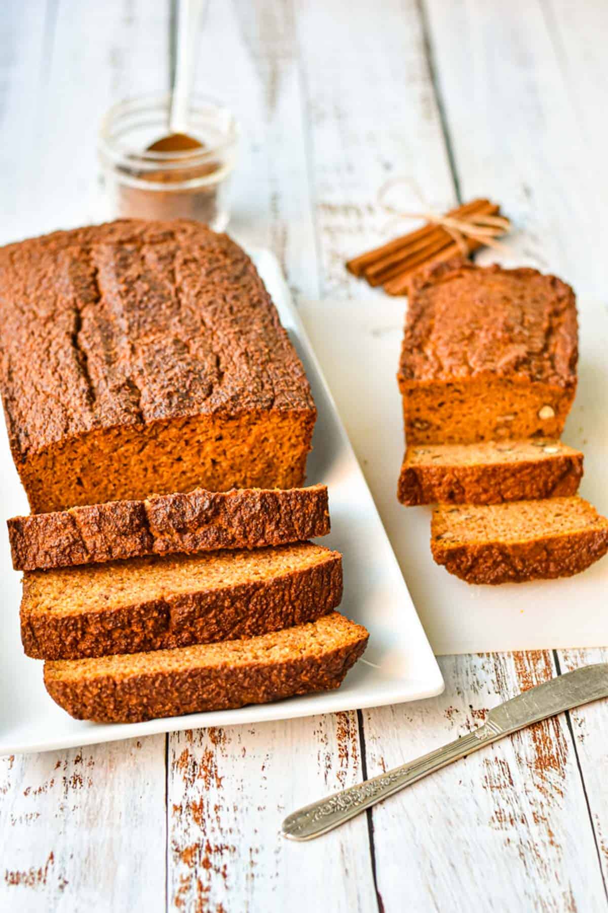 large and small loaves of sliced low fodmap pumpkin bread on a white background