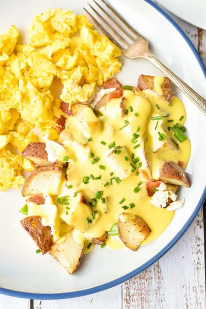 overhead shot of low fodmap breakfast poutine with potatoes, bacon, scallions, and egg whites topped with low fodmap hollandaise