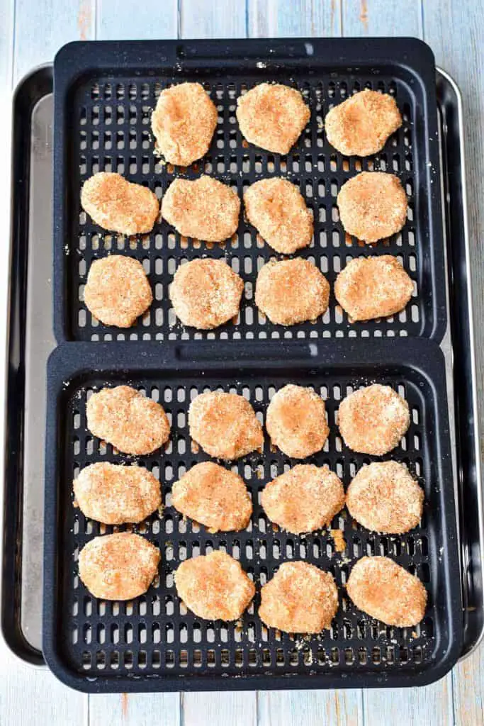 overhead shot of uncooked low fodmap chicken nuggets on air fryer pans prior to being cooked