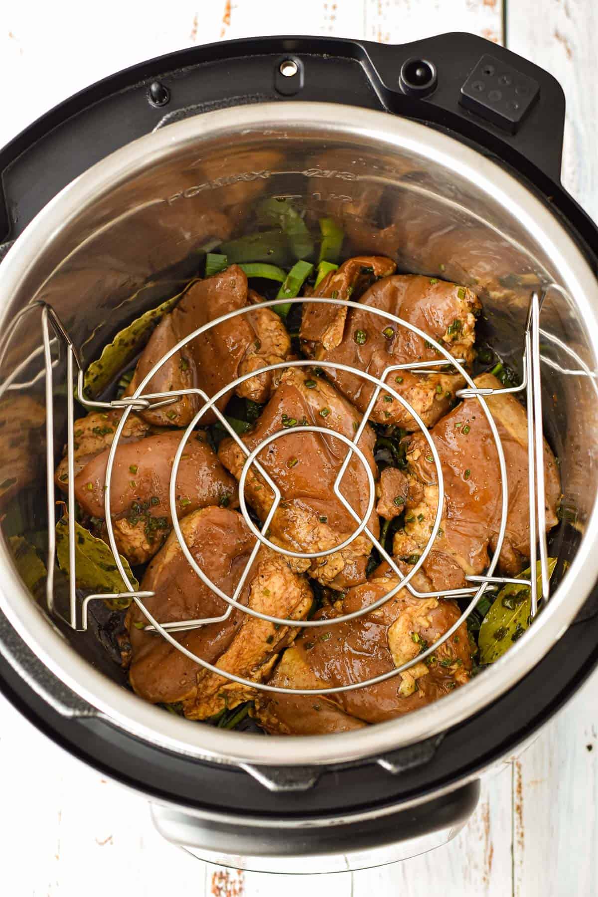 the trivet on top of the chicken thighs in the instant pot for pot-in-pot rice