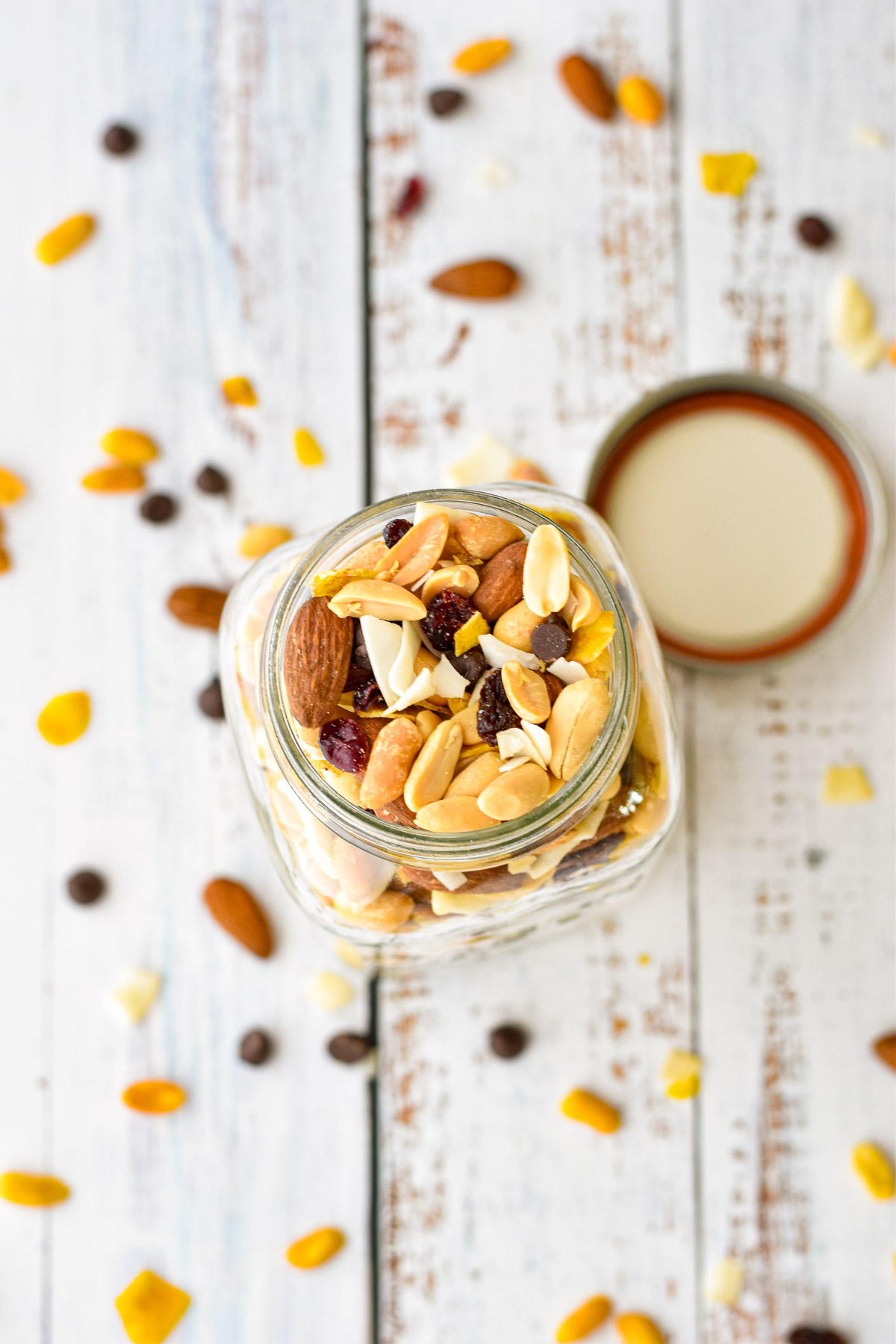 overhead shot of low fodmap trail mix in a glass jar with trail mix spilled around it