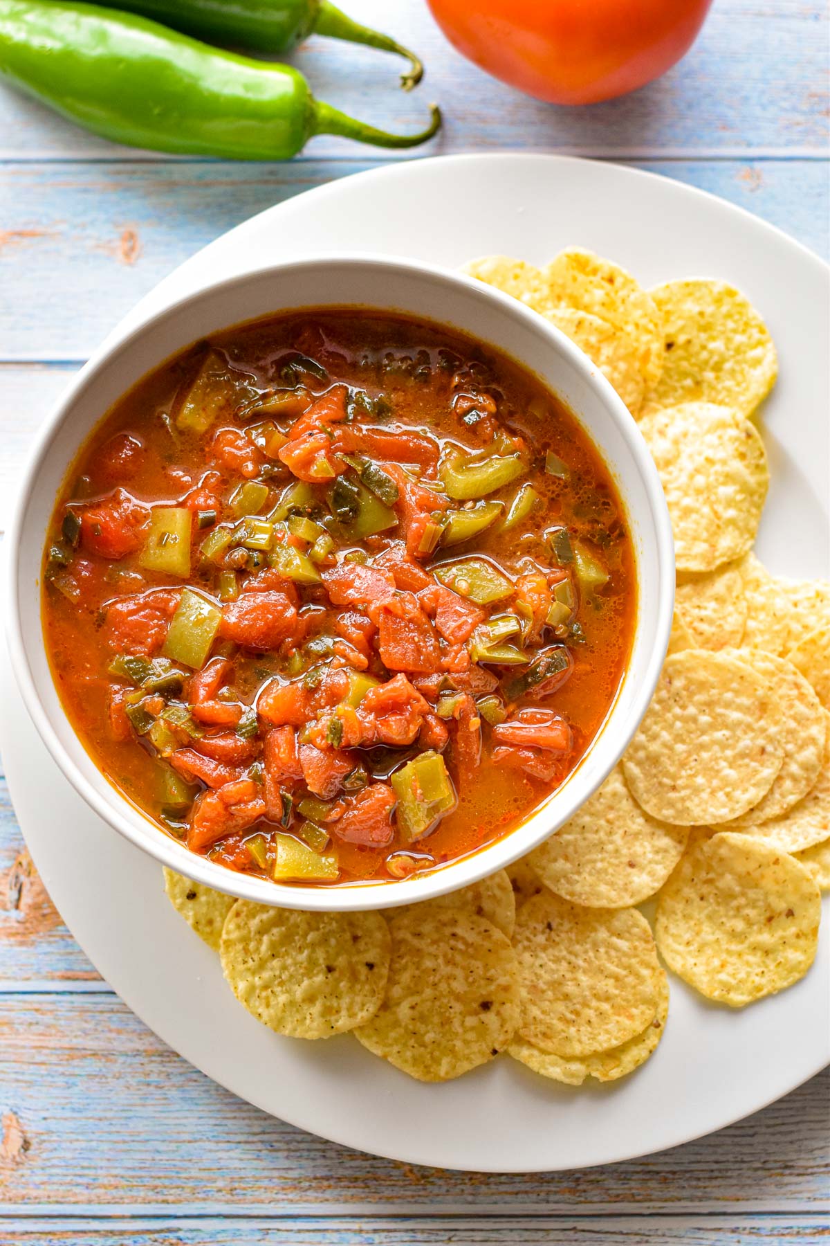 overhead shot of low fodmap instant pot salsa in a white bowl on a plate surrounded by tortilla chips