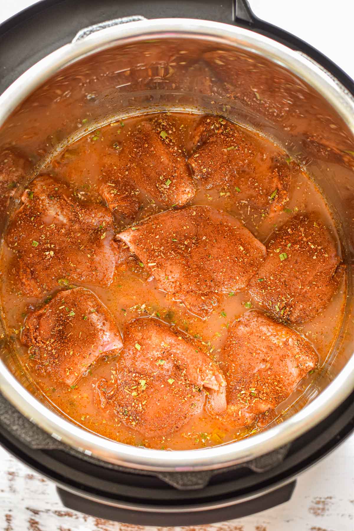 process shot of seasoned chicken thighs laying on top of low FODMAP salsa mixture