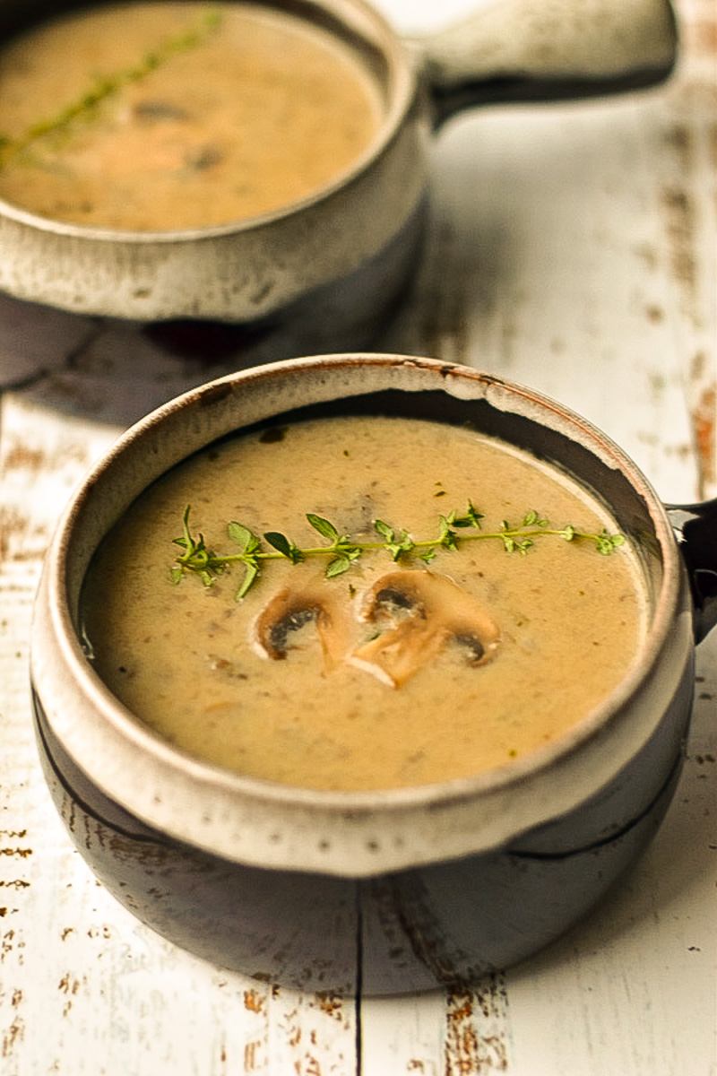 close up shot of dairy-free mushroom soup without cream in a brown bowl with a white frosty edge.