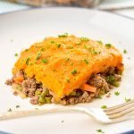 instant pot sweet potato shepherd's pie on a white plate with a blue rim and a fork