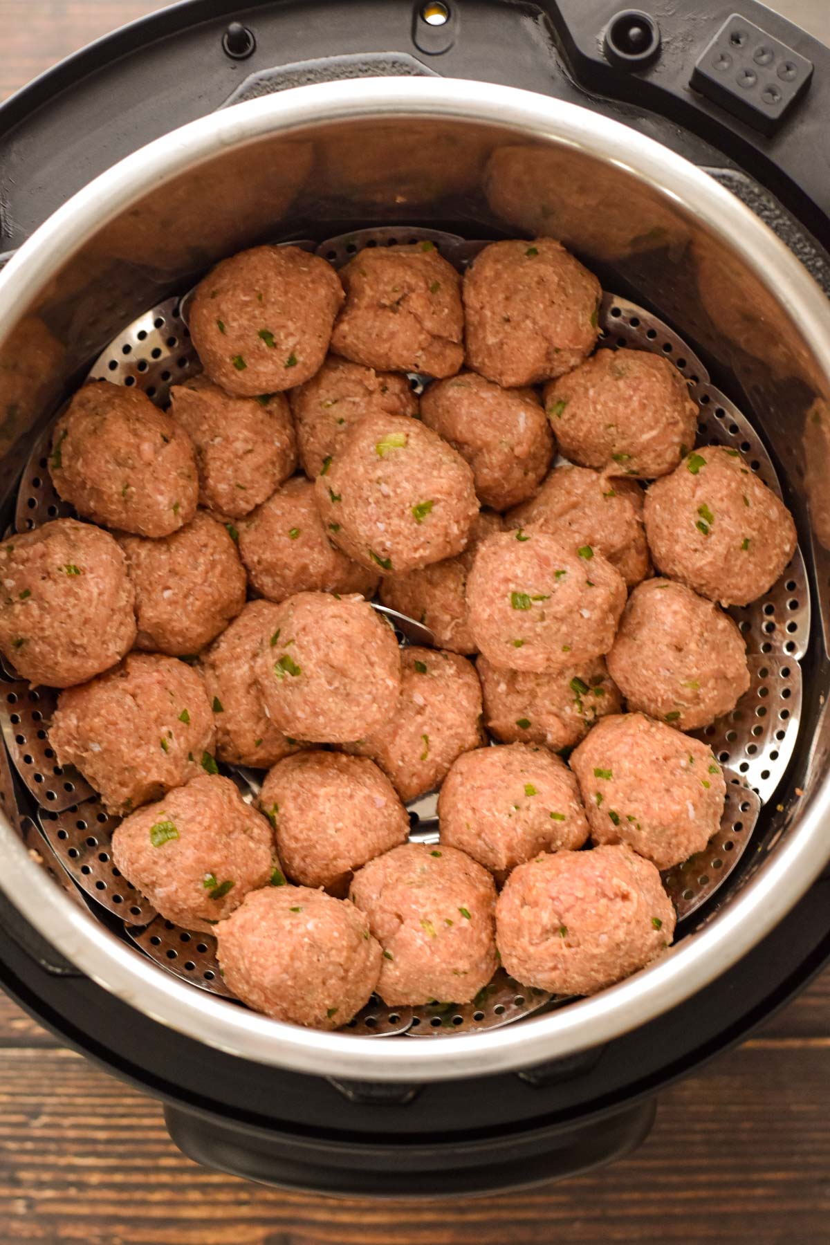 process shot of after raw low fodmap turkey meatballs have been placed on the vegetable steamer in the instant pot