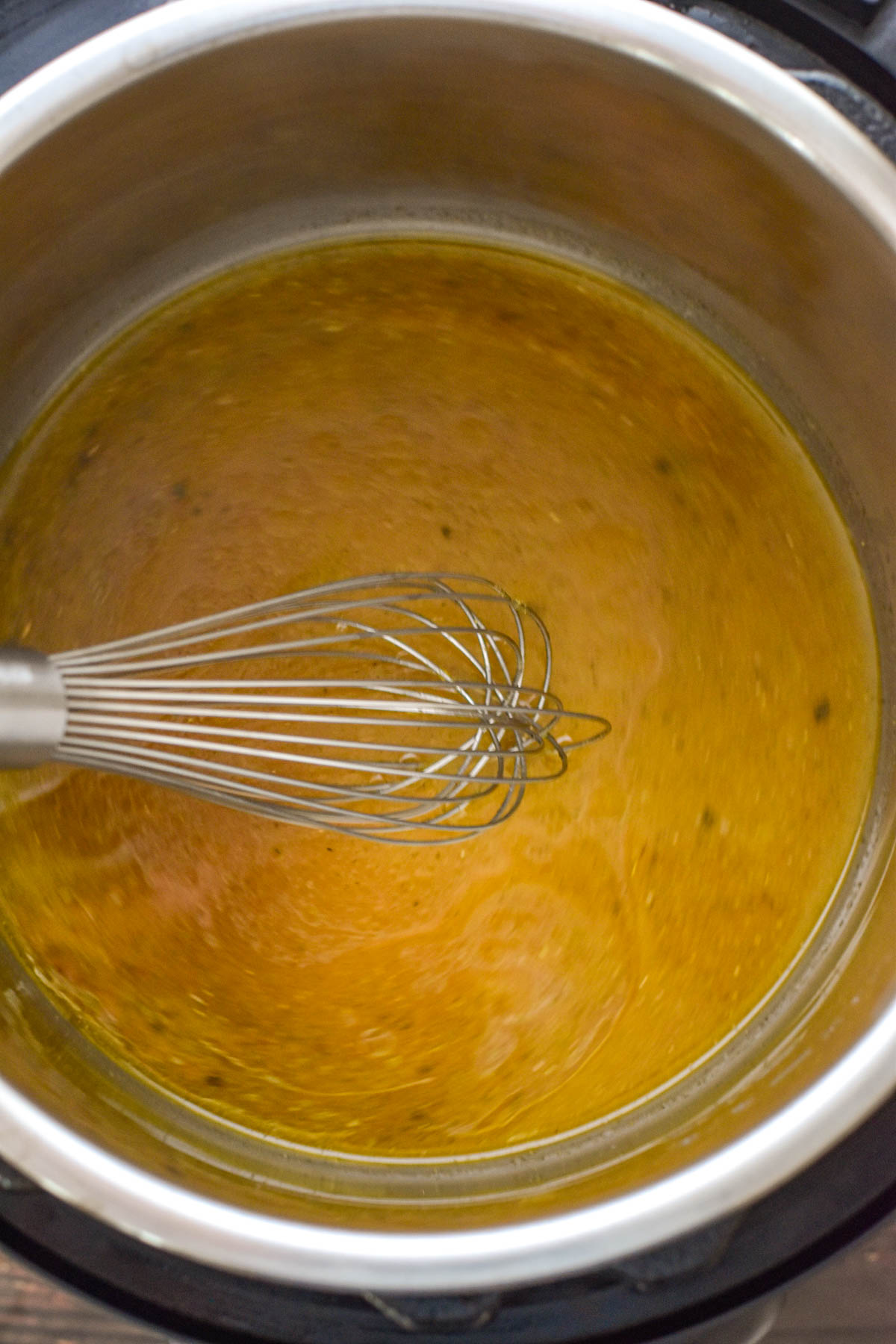 process shot of whisking low fodmap turkey meatball gravy ingredients together in an instant pot