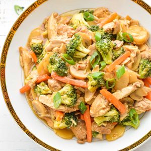 low fodmap chicken stir fry with broccoli, carrots, canned mushrooms, water chestnuts and scallions in a white bowl