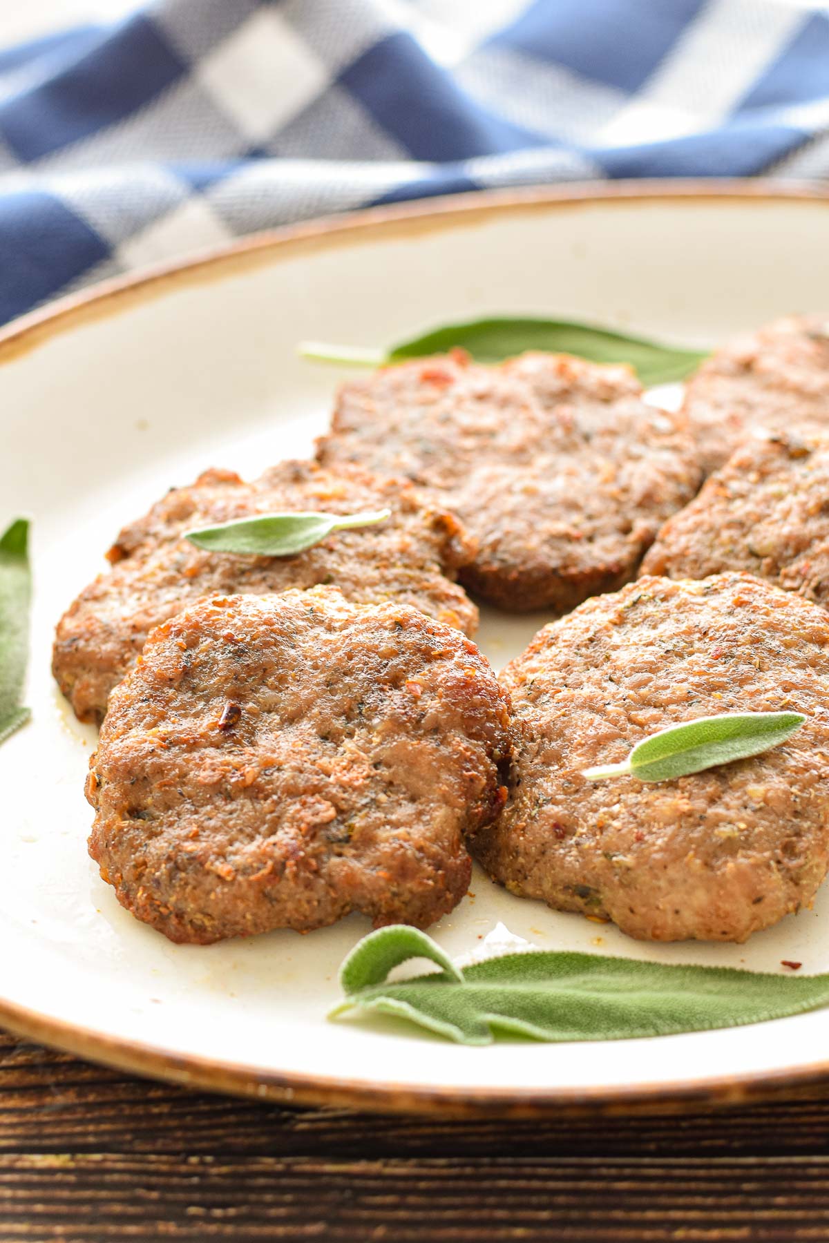 close up of low fodmap sausage patties on a platter garnished with fresh sage