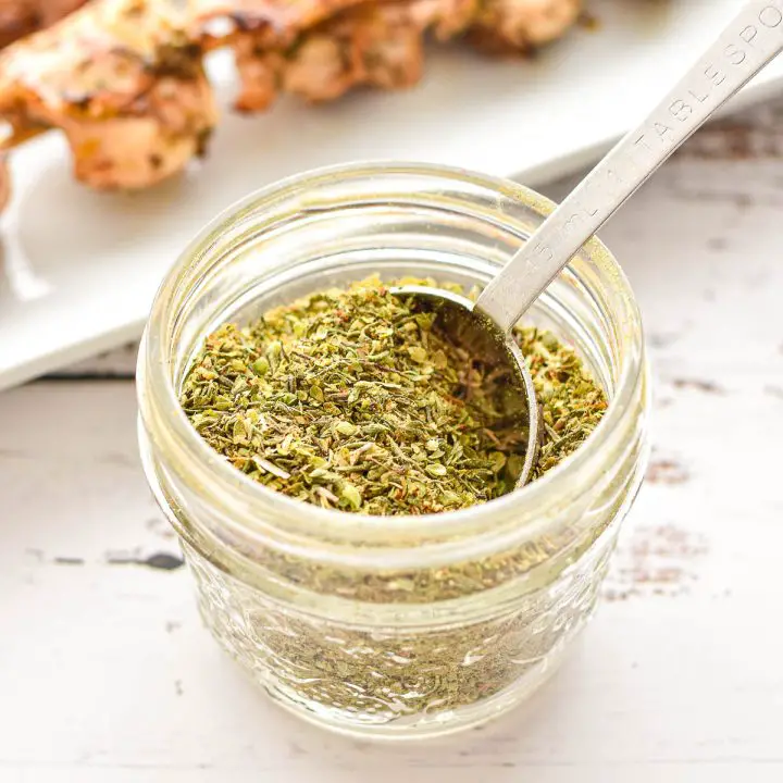 low fodmap greek seasoning in a small jar with a tablespoon
