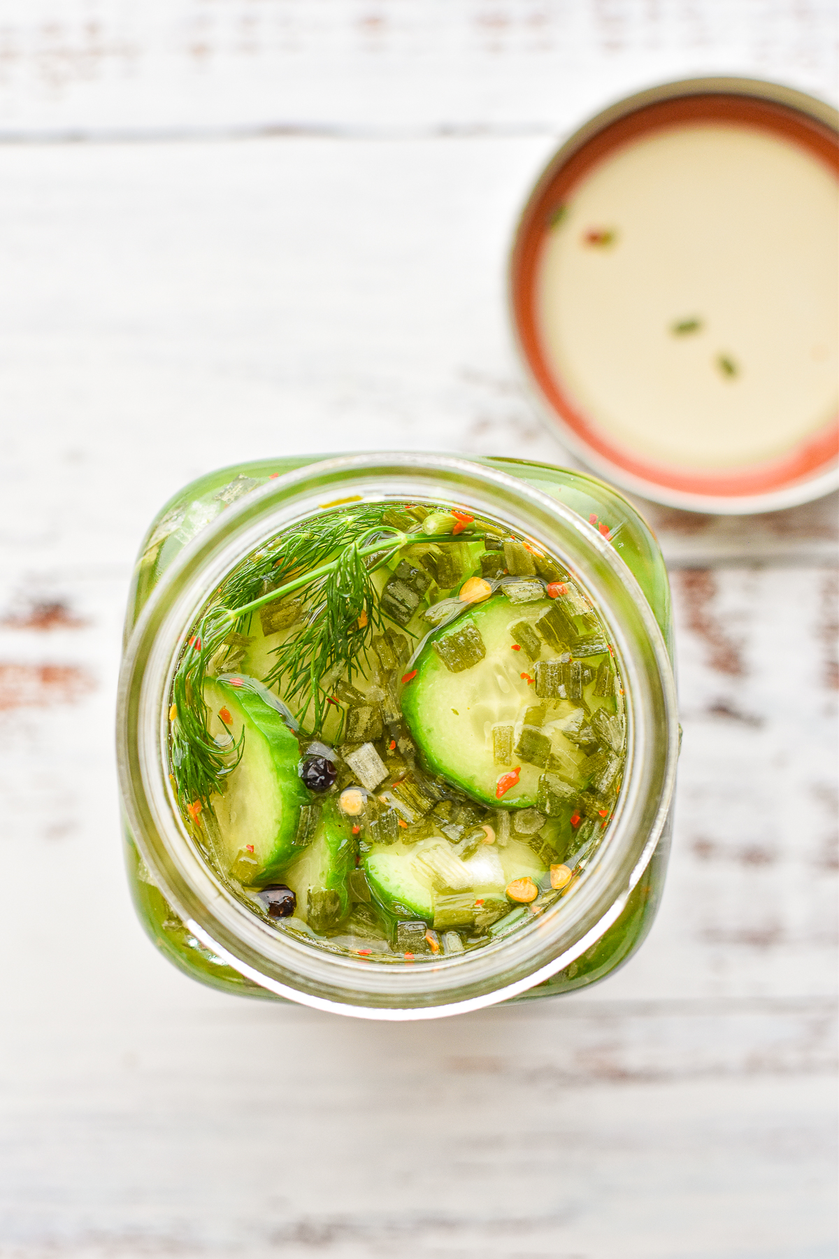 process shot of cucumbers covered in brine in a glass jar