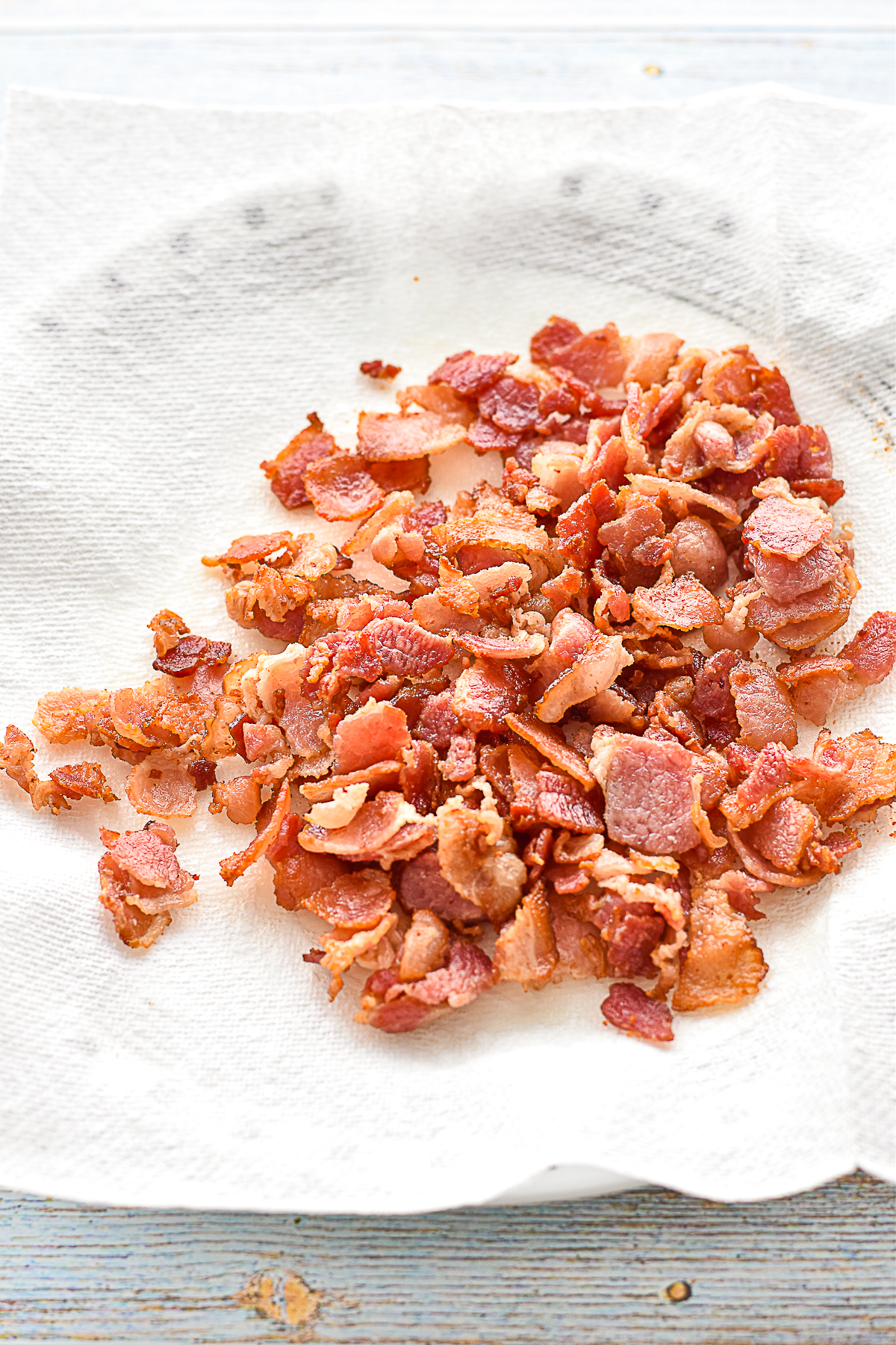 process shot of bacon pieces draining on a paper towel