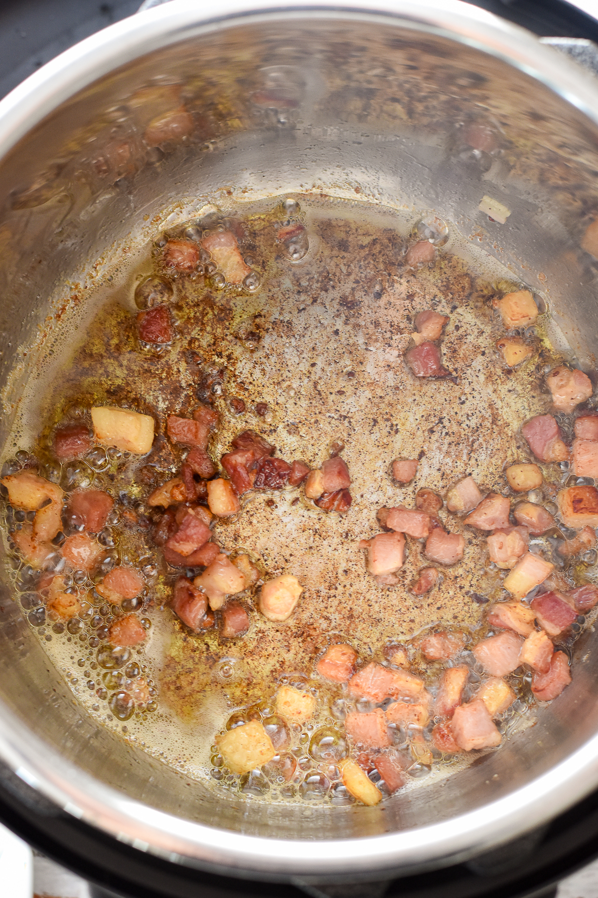 process shot of after pancetta has started browning around the edges after being sauteed in the instant pot.