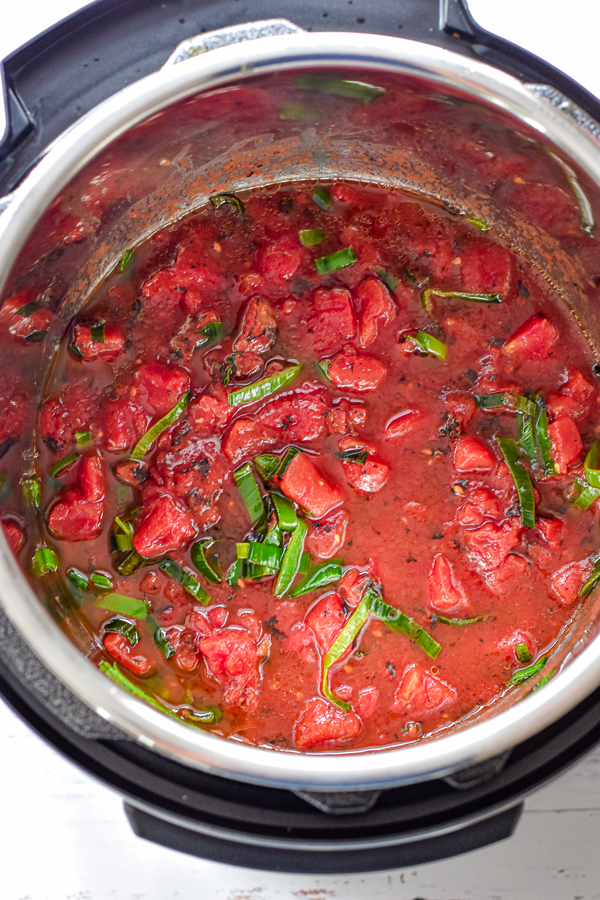 process shot of after tomatoes and salt are added to the instant pot prior to cooking.