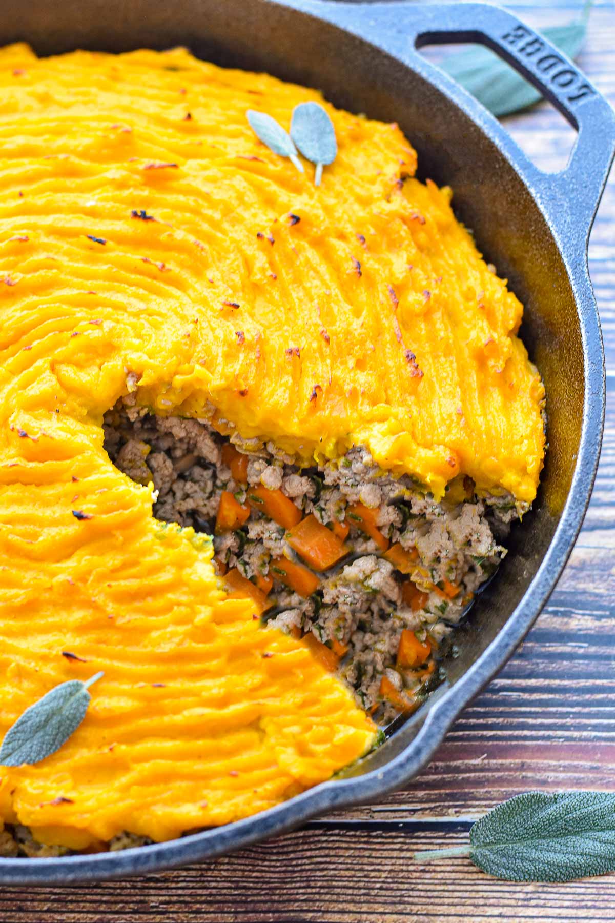 low fodmap low carb shepherd's pie with a squash topping and turkey filling missing a piece in a cast iron skillet.