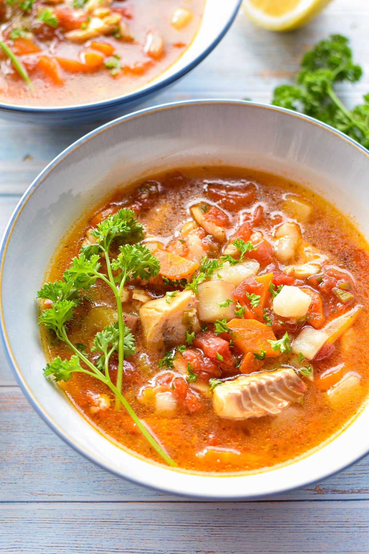 low fodmap fish stew topped with fresh parsley in a soup bowl.