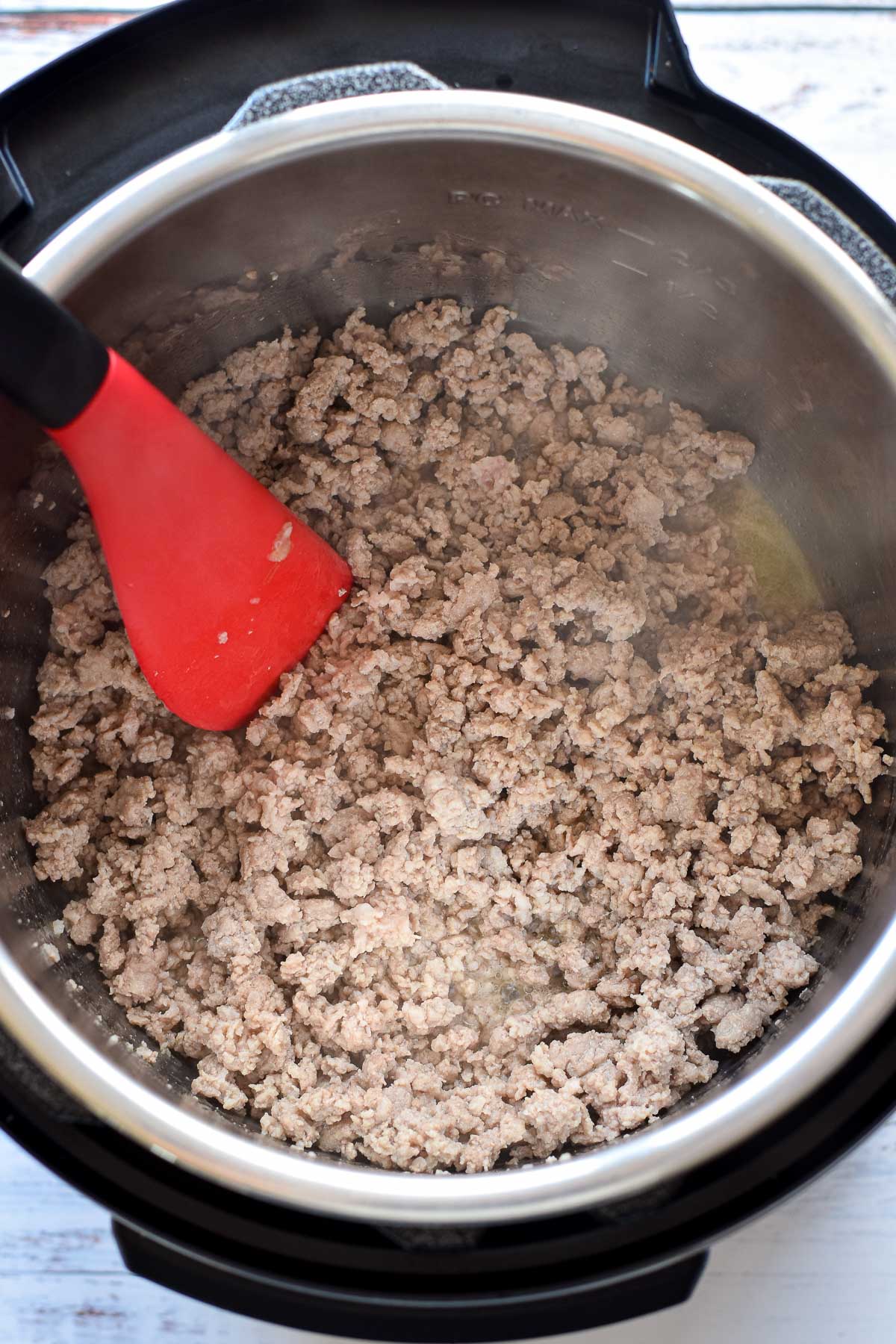ground pork in an instant pot after browning in garlic-infused olive oil with a spatula.